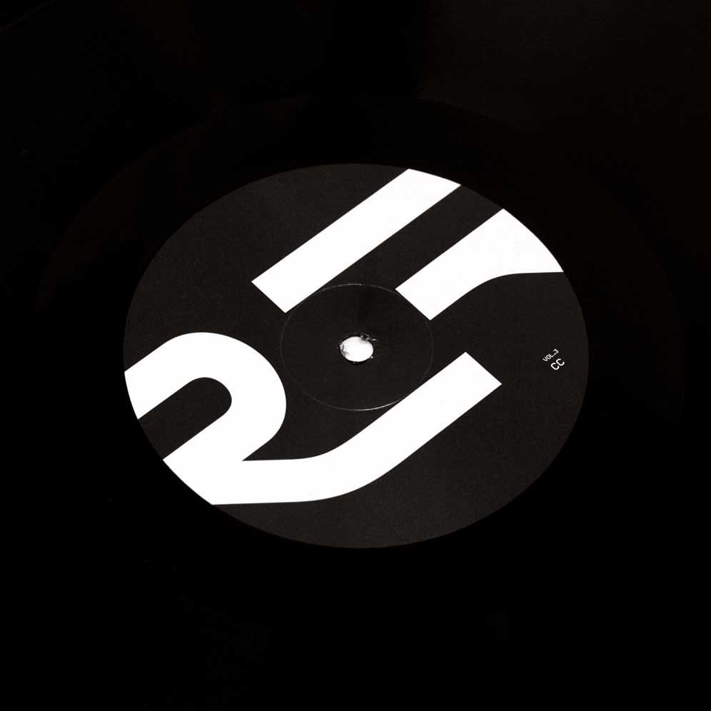 Alva Noto - Xerrox Vol. 3 (Vinyl 2LP) A vinyl record label with the minimalist white geometric Xerrox Vol. 3 logo on a black background, photographed in low light.