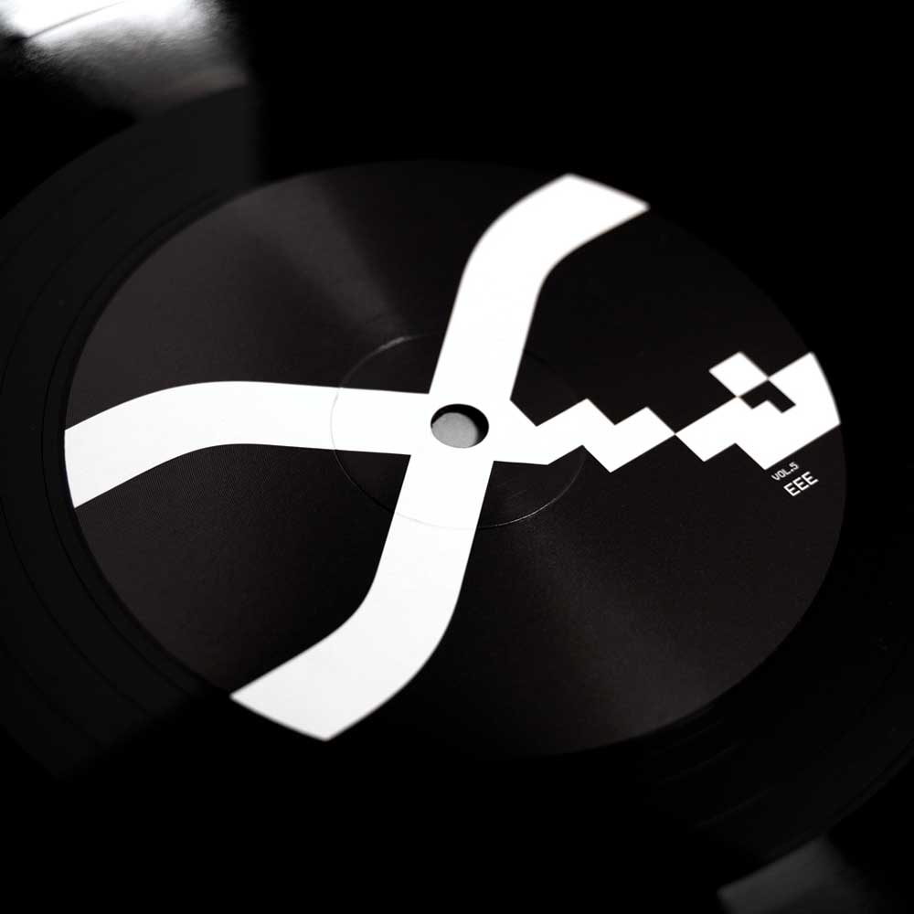 Alva Noto - Xerrox Vol. 5 (Vinyl 2LP) A close-up of a black vinyl record with the bold Xerrox Vol 5. white abstract logo printed across the center label.