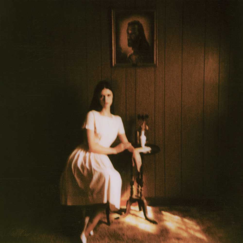 Ethel Cain - Preacher's Daughter (Vinyl 2LP) record album cover showing a woman in a white dress sitting in a dimly lit room with a painting on the wall.