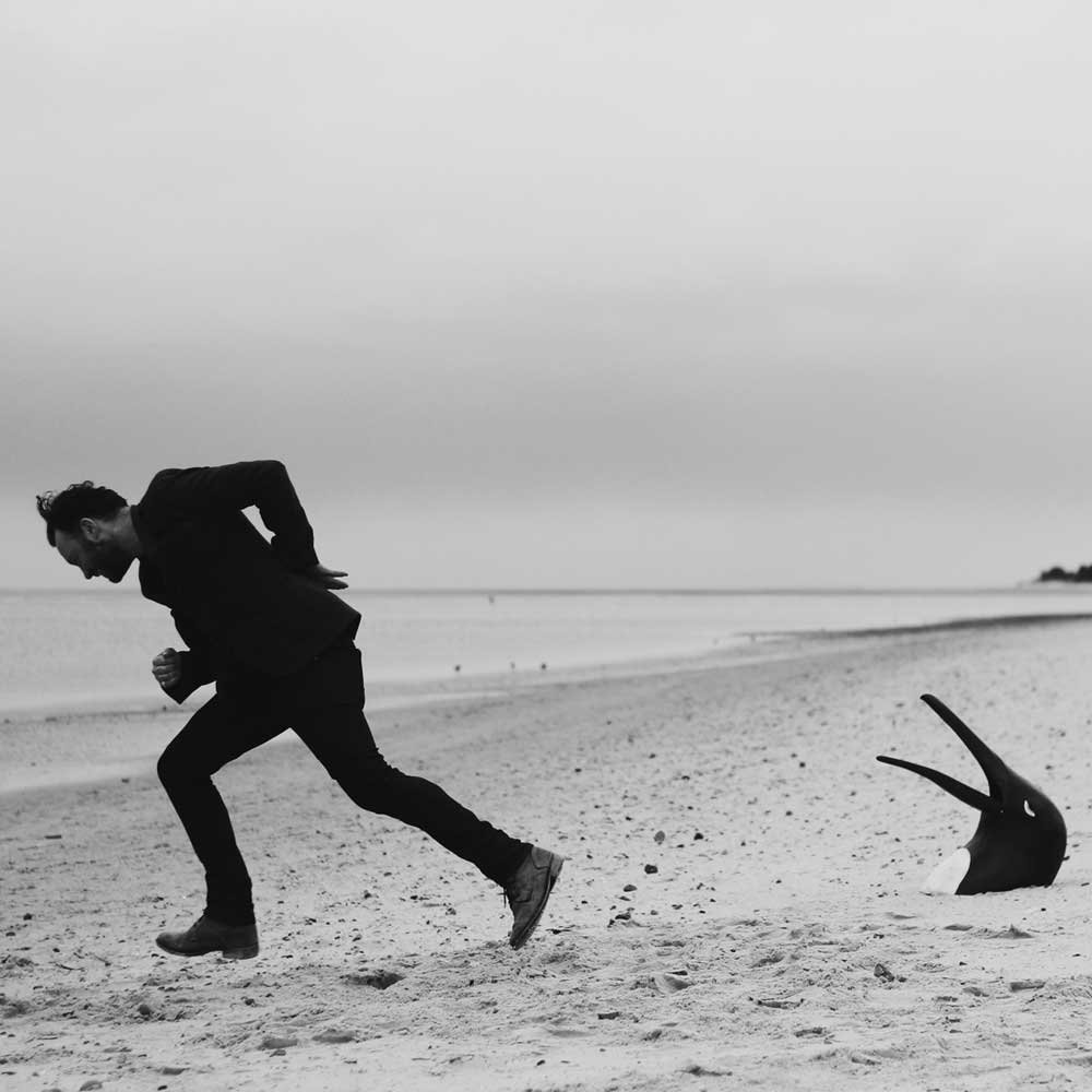 Penguin Café - The Imperfect Sea (Vinyl LP Clear) striking cover artwork designed by FELD under the art direction of label founder Robert Raths, resembling a lone figure adapting to and accepting its surrounding environment.