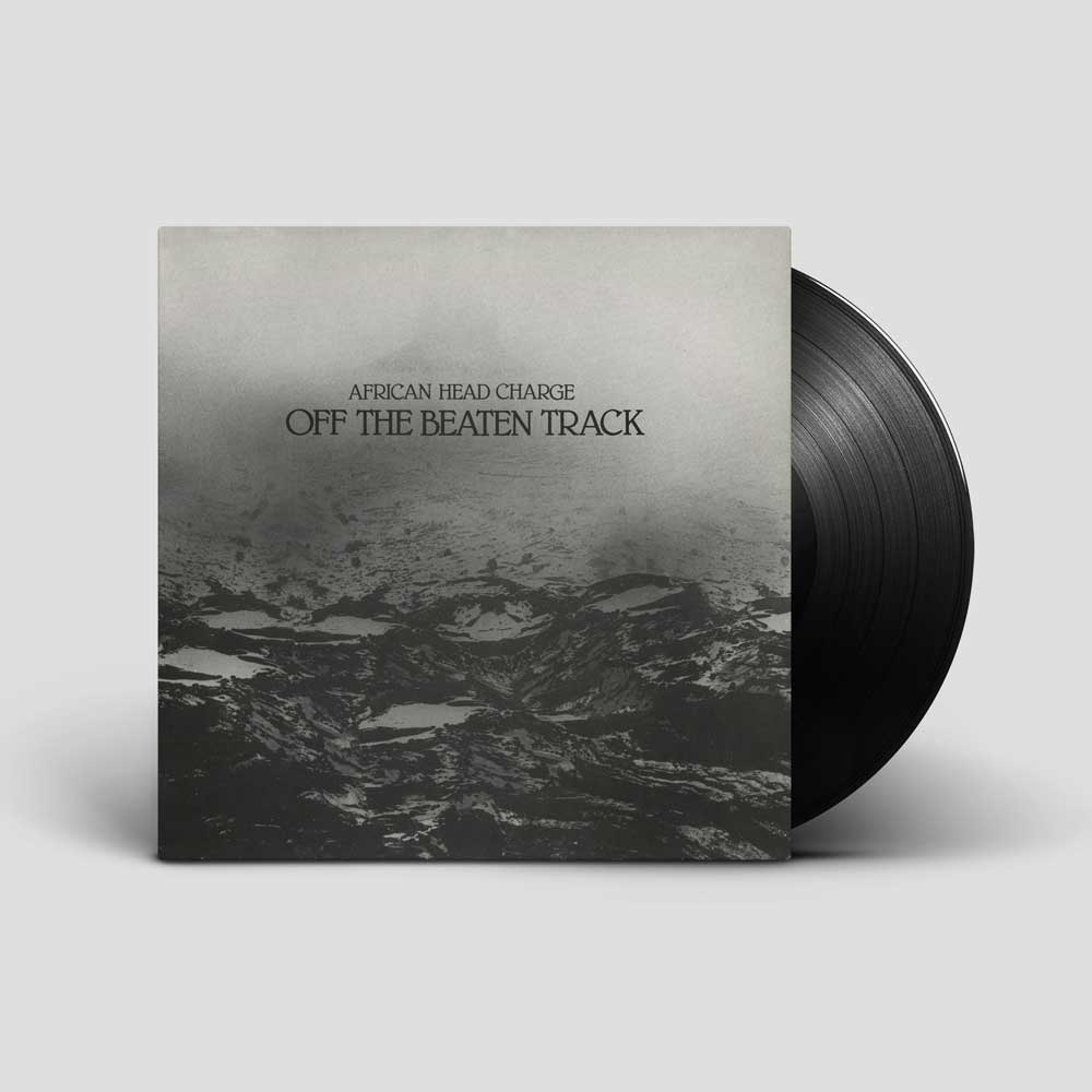 African Head Charge - Off The Beaten Track (Vinyl LP) A vinyl record partially pulled from its sleeve, shown on a light gray background. The album cover features a monochrome landscape photograph with the text 'AFRICAN HEAD CHARGE' and 'OFF THE BEATEN TRACK' printed near the top.