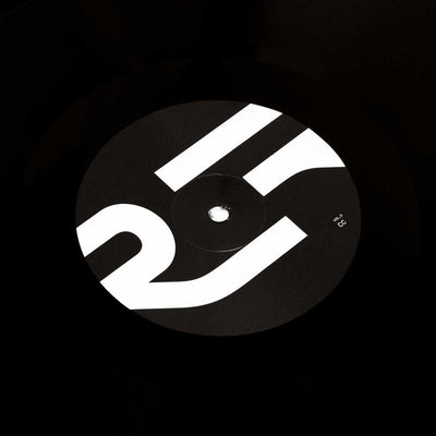 Alva Noto - Xerrox Vol. 3 (Vinyl 2LP) A vinyl record label with the minimalist white geometric Xerrox Vol. 3 logo on a black background, photographed in low light.