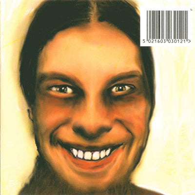 Aphex Twin - ...I Care Because You Do (Vinyl 2LP) A stylized painted portrait of a smiling person with dark hair on a cream background, with a barcode in the top-right corner.