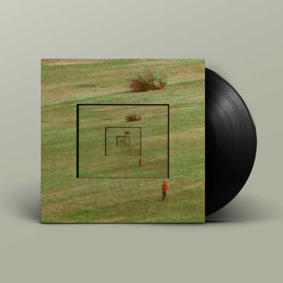 Bibio and Dorian Concept - Answers (Vinyl LP) A vinyl record partially pulled from its sleeve, showing the album cover artwork of a grassy field with concentric square lines and a small figure, against a muted grey background.