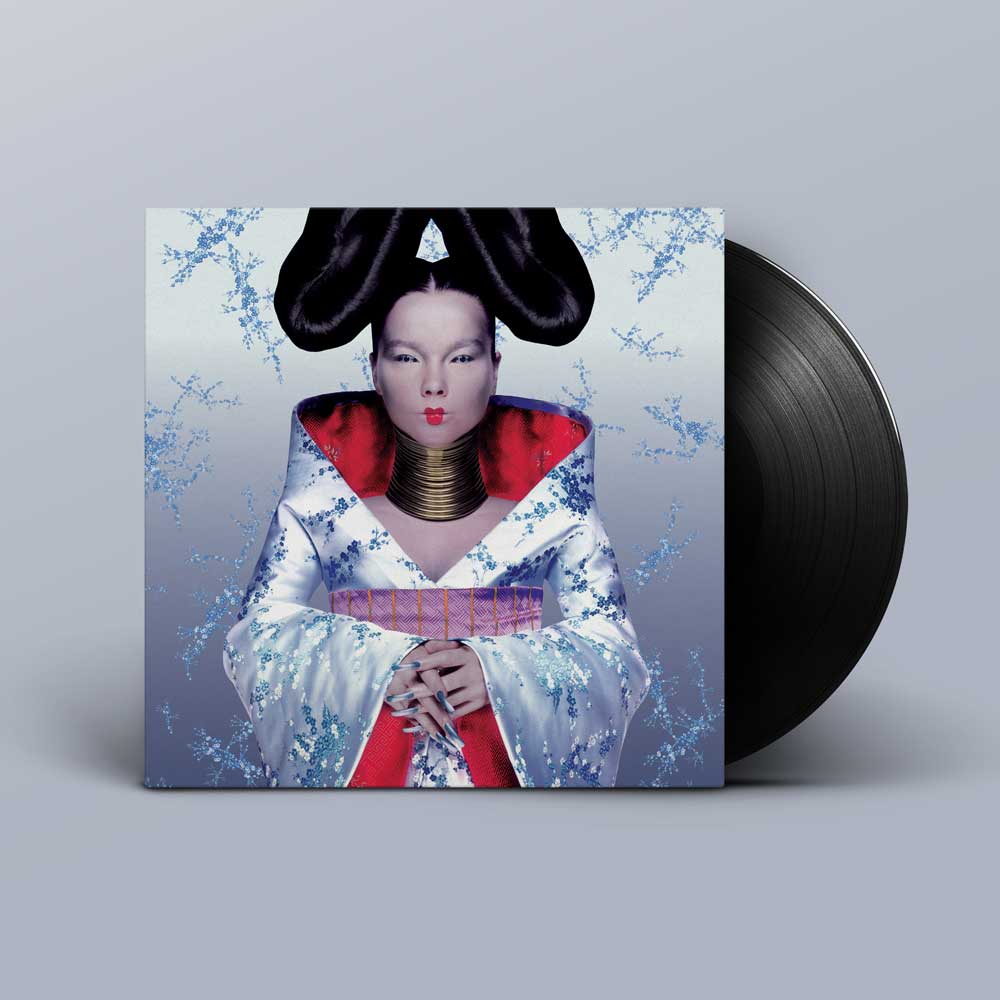 Björk - Homogenic (Vinyl LP) Vinyl record album with a square jacket showing a stylised portrait of a woman in a white kimono with red accents and black hair, with a black vinyl record partially visible behind it on a light grey background.