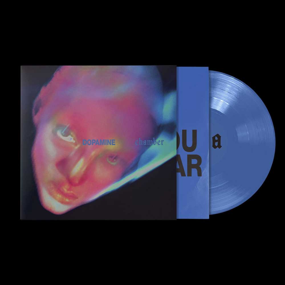 Fontaines D.C. - Dopamine Chamber (Vinyl LP Blue Marble) Vinyl record album cover with a blue marble LP partially pulled from the sleeve, shown on a black background. The sleeve features a distorted close-up portrait in pink, purple, and blue tones, with the text 'DOPAMINE chamber' and partial title text visible.