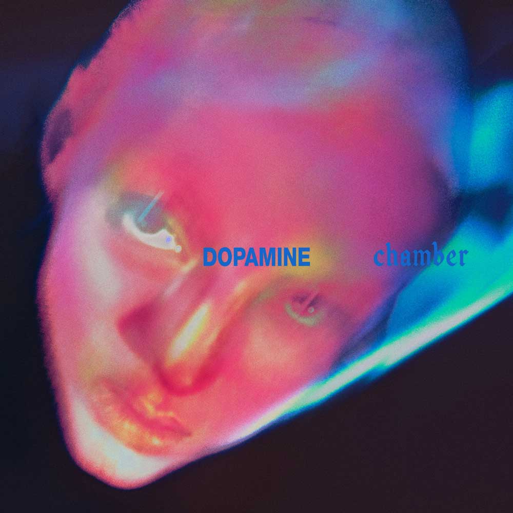 Fontaines D.C. - Dopamine Chamber (Vinyl LP Blue Marble) Album cover art for 'Dopamine chamber' featuring a close-up, distorted, and colorful portrait of a face in pink, blue, and purple hues with blue text overlay.
