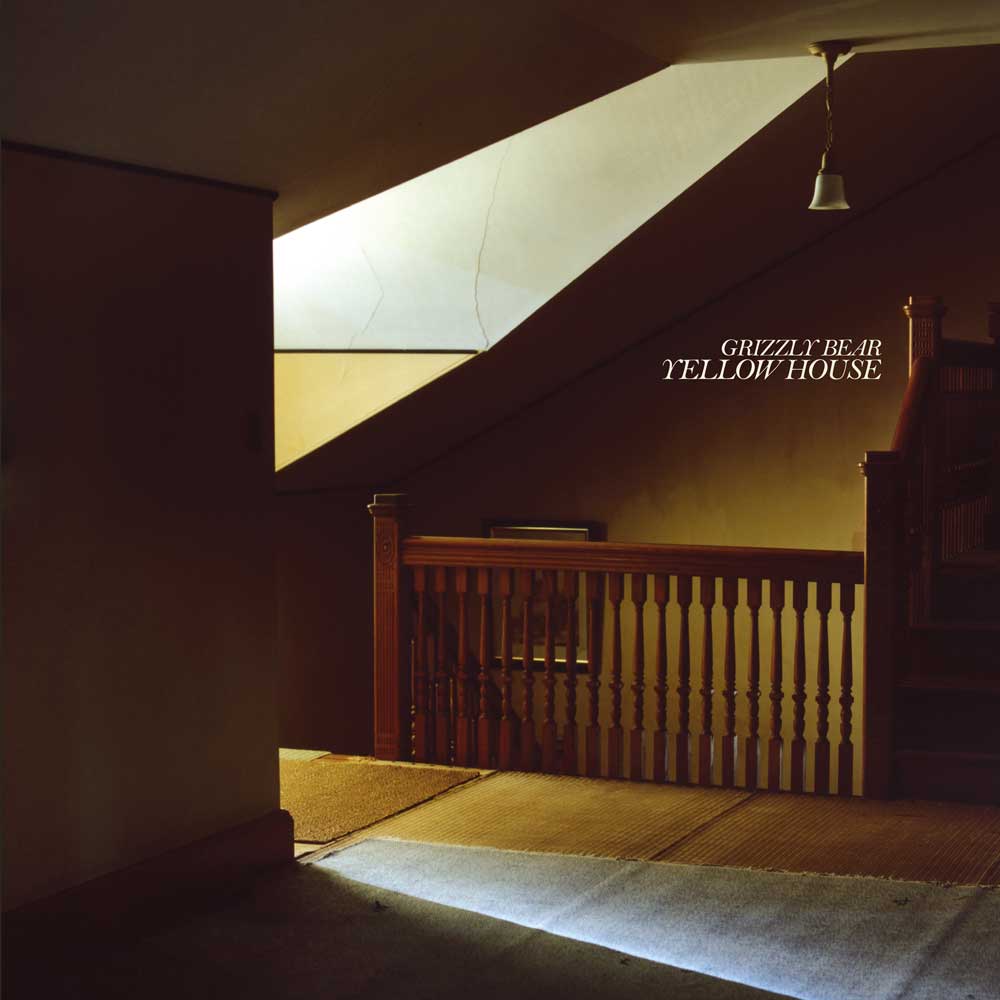 Grizzly Bear - Yellow House (Vinyl 2LP Cream White) Album cover art for Grizzly Bear's 'Yellow House', featuring a warm-toned photograph of an interior staircase with a wooden railing and dramatic light beams.