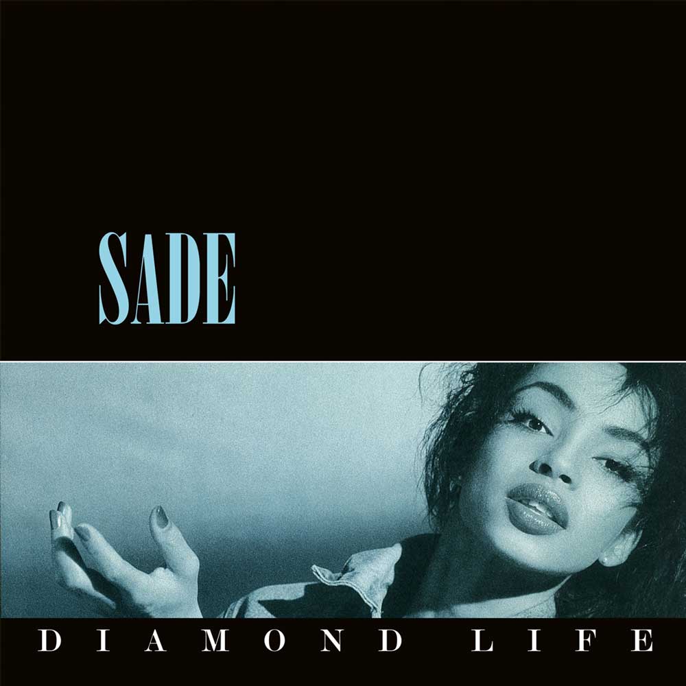 Album cover for Sade's 'Diamond Life' featuring a black top section with the artist's name in light blue, and a lower photo strip in a cool blue-gray tint showing part of the model with her hand raised.