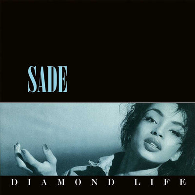 Album cover for Sade's 'Diamond Life' featuring a black top section with the artist's name in light blue, and a lower photo strip in a cool blue-gray tint showing part of the model with her hand raised.
